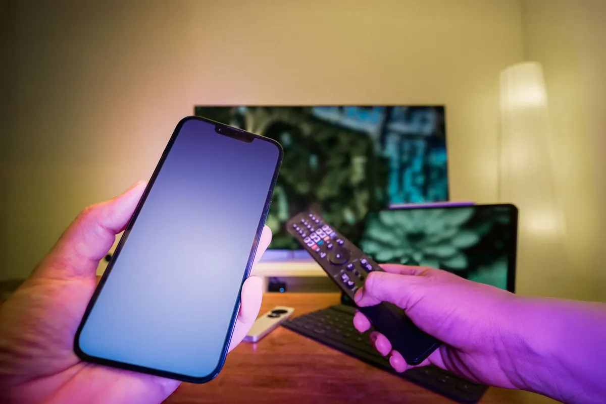 A phone, laptop and television in a home viewing setup